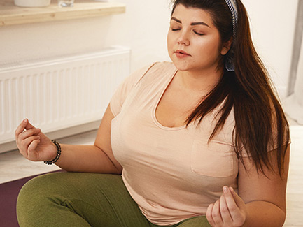 Woman sitting with closed eyes in a yoga position.